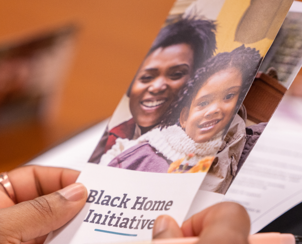 Photo of hands holding a Black Home Initiative pamphlet.