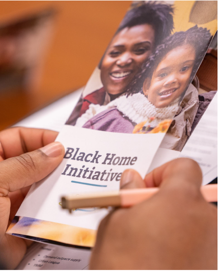 Photo of hands holding a Black Home Initiative pamphlet.